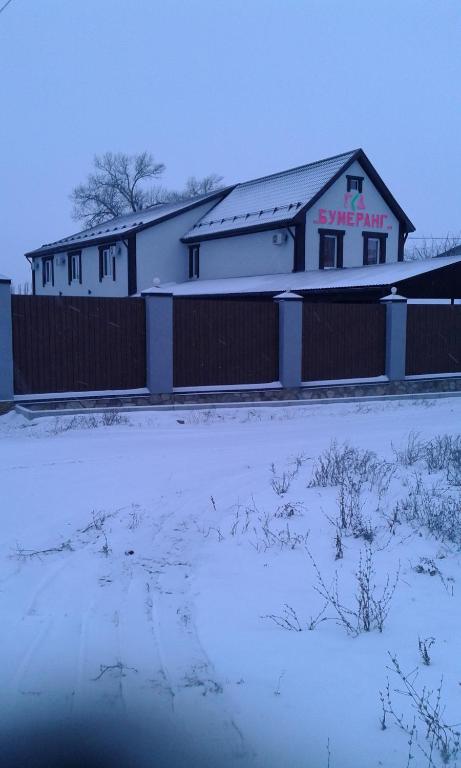 カメンスク・シャフチンスキーにあるGuesthouse Boomerangの雪の中に柵を持つ建物