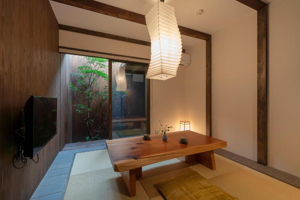 a living room with a wooden table and a window at Akebono an Machiya House in Kyoto