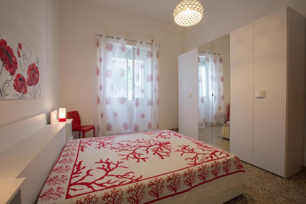 Schlafzimmer mit einem Bett mit einer roten und weißen Tagesdecke in der Unterkunft Villetta Angela in Torre San Giovanni Ugento