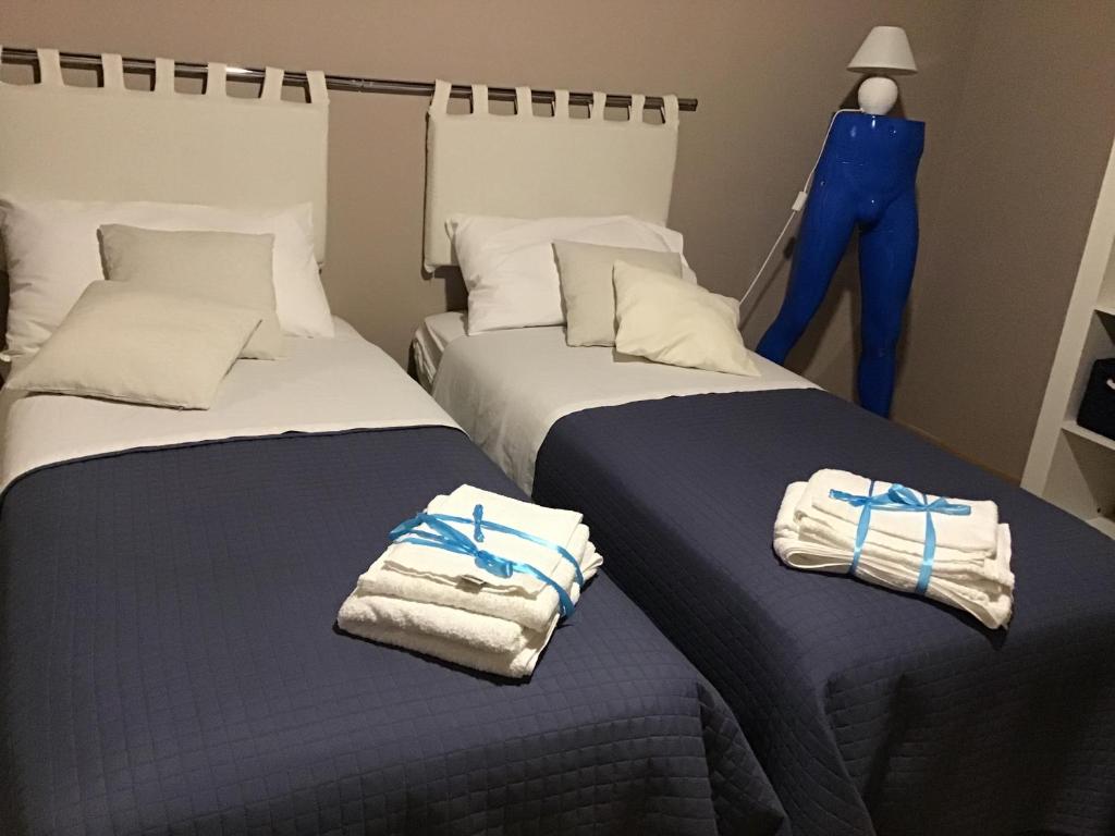 2 łóżka w pokoju z ręcznikami w obiekcie Original b&b w mieście Porto Torres
