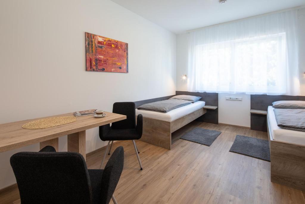 a room with a bed and a desk and a table at Haus an der Krems in Kremsmünster