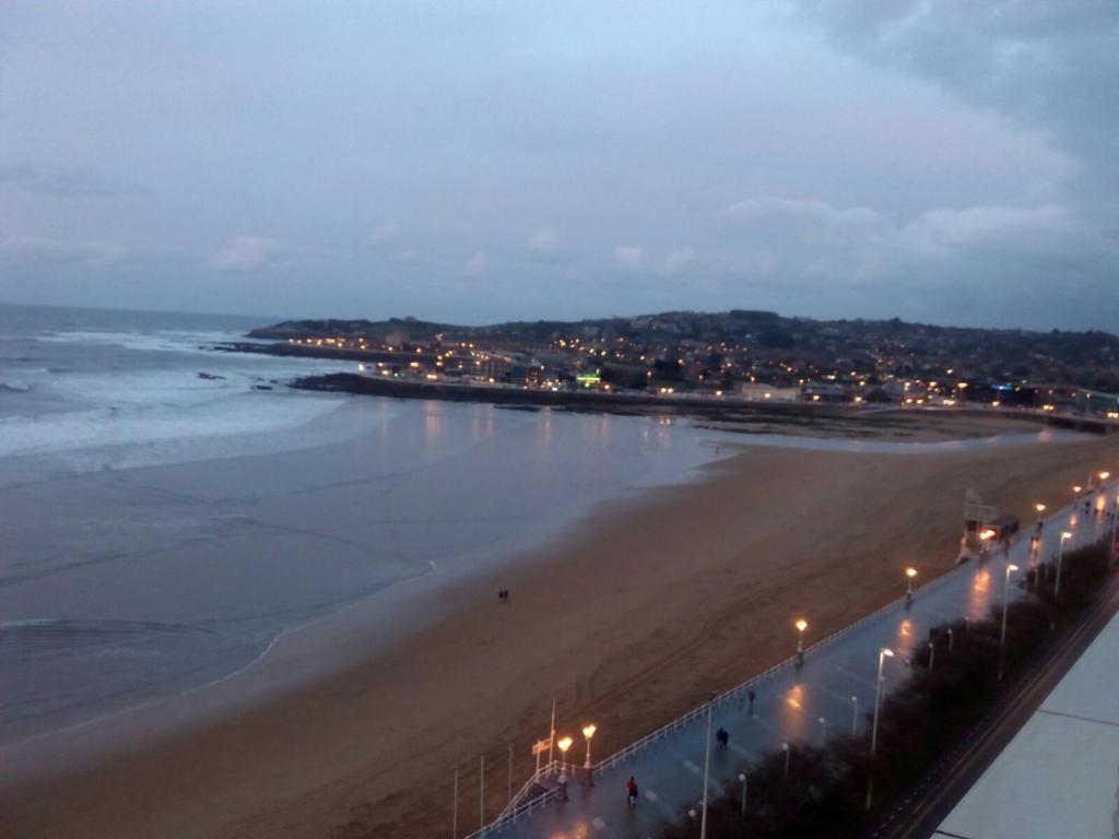 - une vue sur la plage la nuit avec des lumières de rue dans l'établissement Mirandoalmar, à Gijón