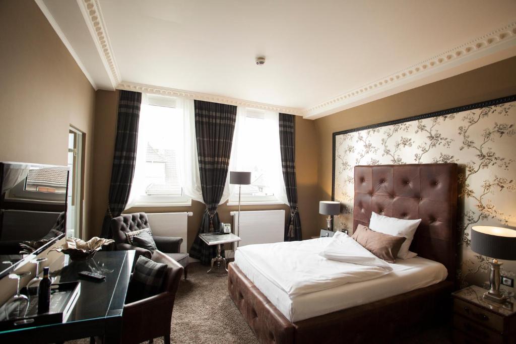 エッセンにあるBoutique-Hotel GEORGESのベッドとデスクが備わるホテルルームです。