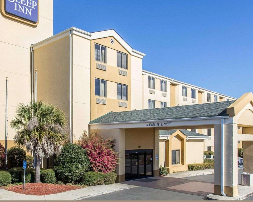 een hotelgebouw met een bord waarop staat: Deanery bij Sleep Inn Columbia in Columbia