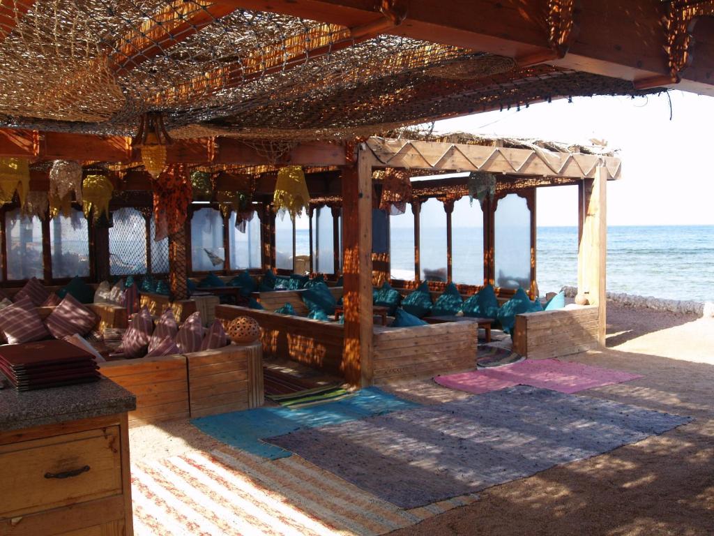 a pavilion on a beach with the ocean in the background at Star Of Dahab Hotel in Dahab