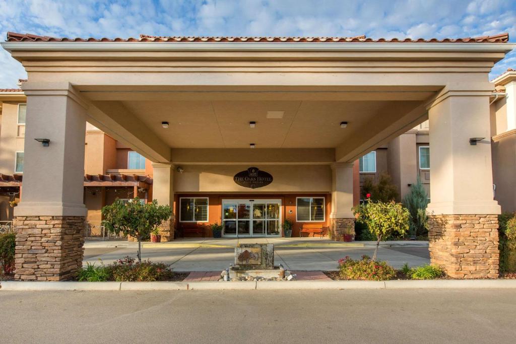Vorderansicht eines Hotels mit einem Gebäude in der Unterkunft The Oaks Hotel & Suites in Paso Robles
