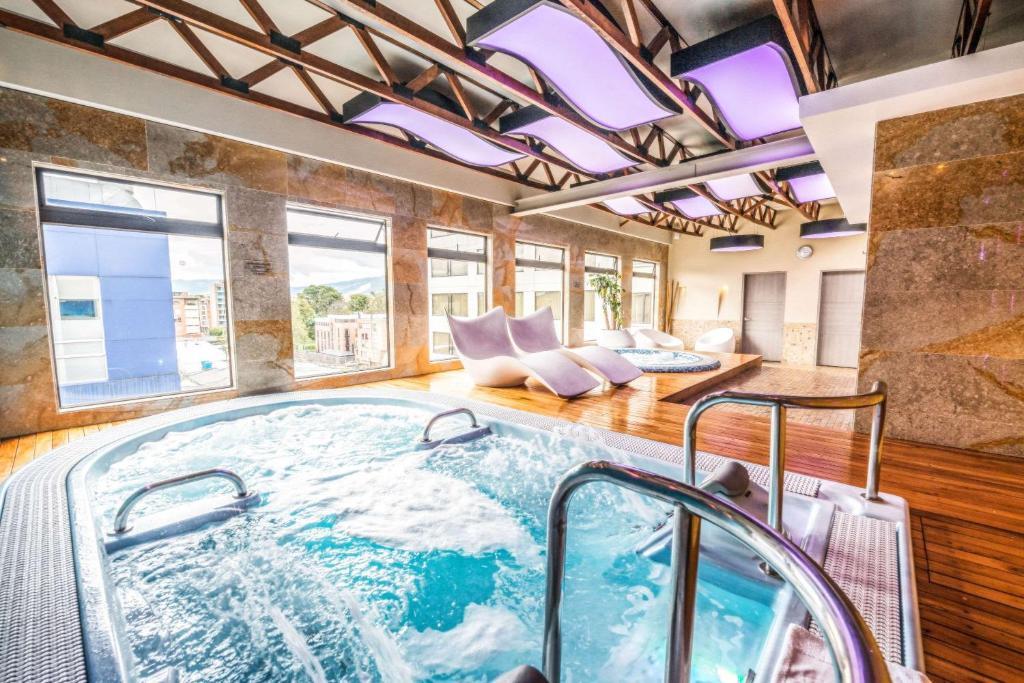 a large hot tub in a room with windows at Bogota Plaza Hotel in Bogotá