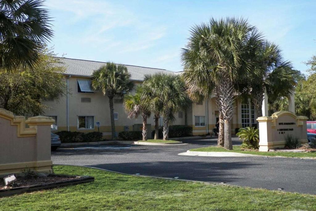 een gebouw met palmbomen ervoor bij Quality Inn in Gulf Shores