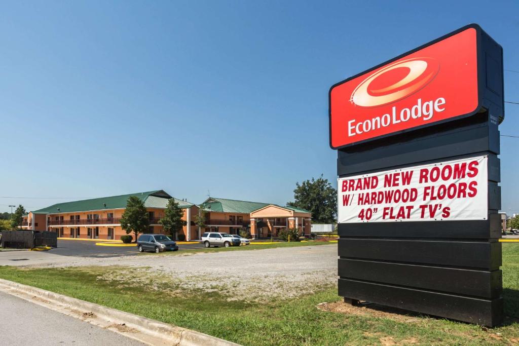 een bord voor een dealer met een gebouw bij Econo Lodge in Decatur