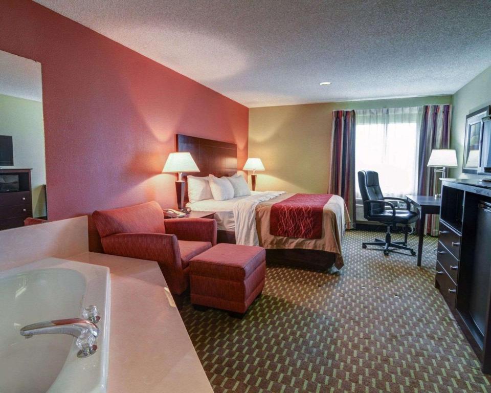 a hotel room with a bed and a bathroom at Quality Inn & Suites Pine Bluff AR in Pine Bluff