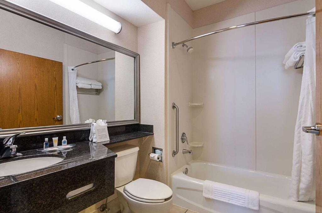 a bathroom with a sink and a toilet and a shower at Quality Suites in Springdale