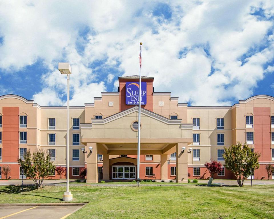 a building with a sign on the front of it at Sleep Inn & Suites Springdale West in Springdale