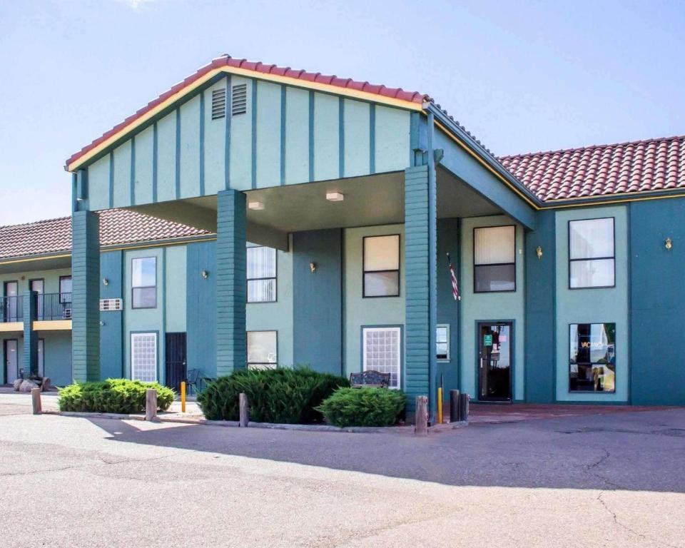 um grande edifício azul com um telhado vermelho em Rodeway Inn Silver Creek Inn em Taylor