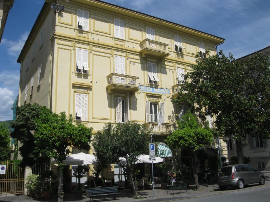 a yellow building with a bench in front of it at Hotel Miramare in Lavagna