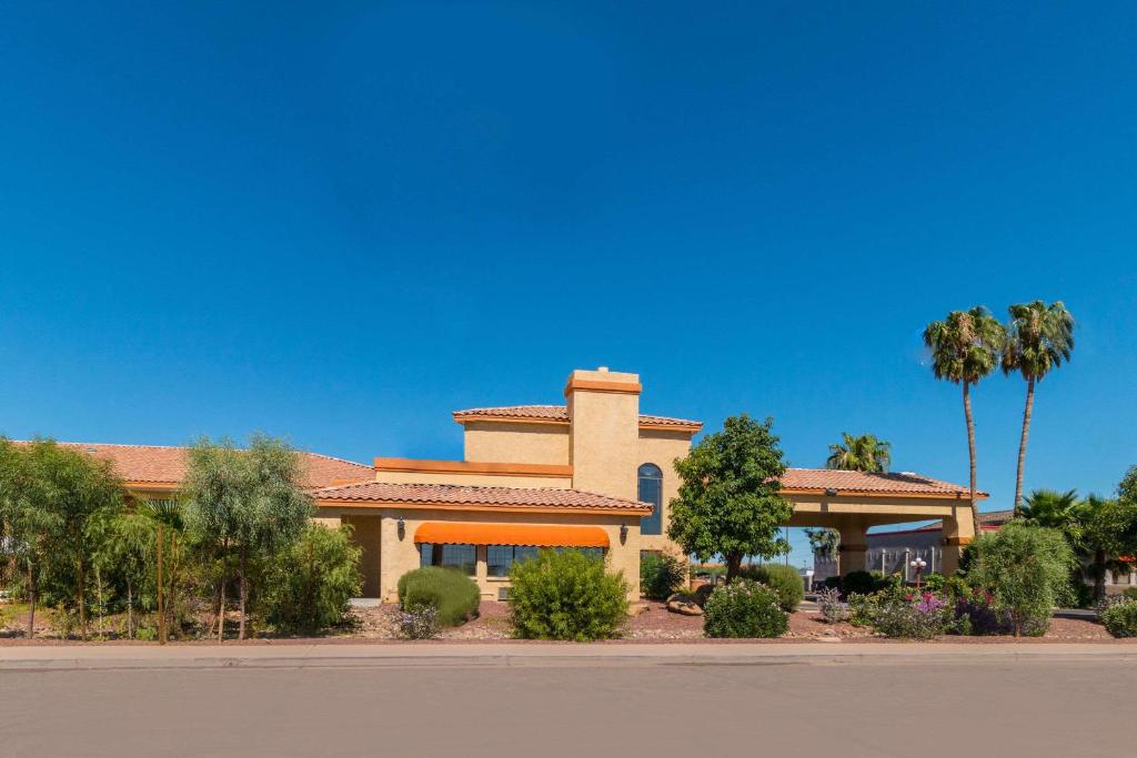 a building with palm trees in front of a street at Quality Inn Casa Grande I-10 in Casa Grande