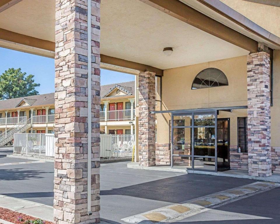 un edificio con un pilar de ladrillo y una puerta de cristal en Quality Inn & Suites Woodland - Sacramento Airport en Woodland