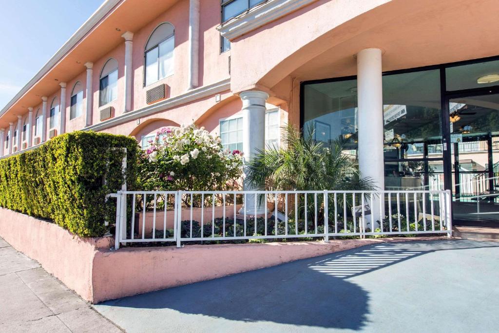 un edificio con una valla blanca delante de él en Rodeway Inn near Melrose Ave, en Los Ángeles