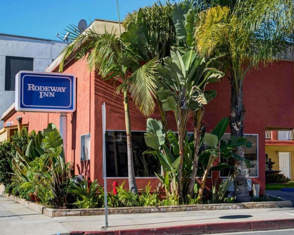 ein Schild vor einem Gebäude mit Palmen in der Unterkunft Rodeway Inn near Venice Beach in Los Angeles