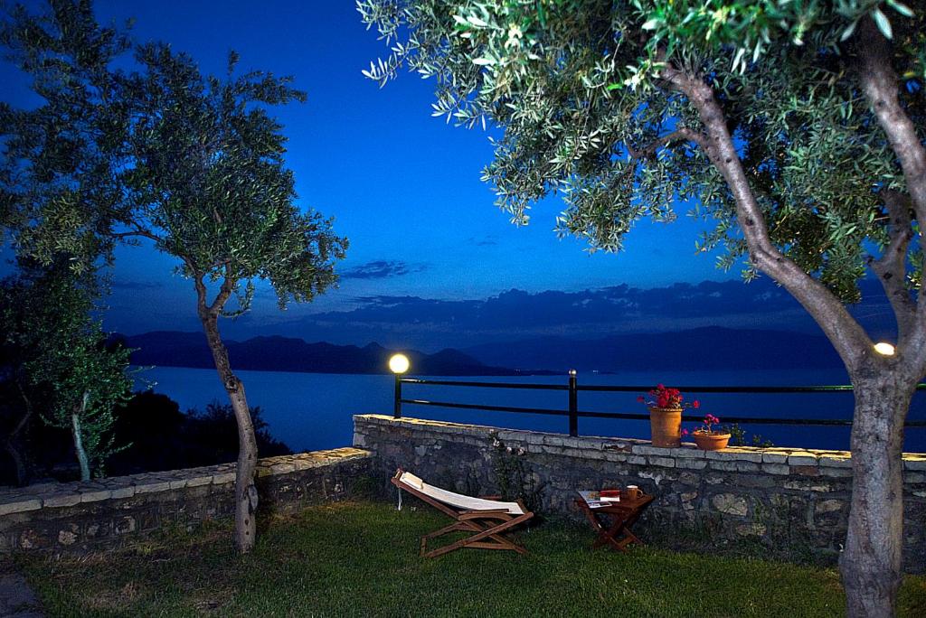 ニキアナにあるVilla Magemenouの水辺の景色を望む壁の横にベンチが備わります。