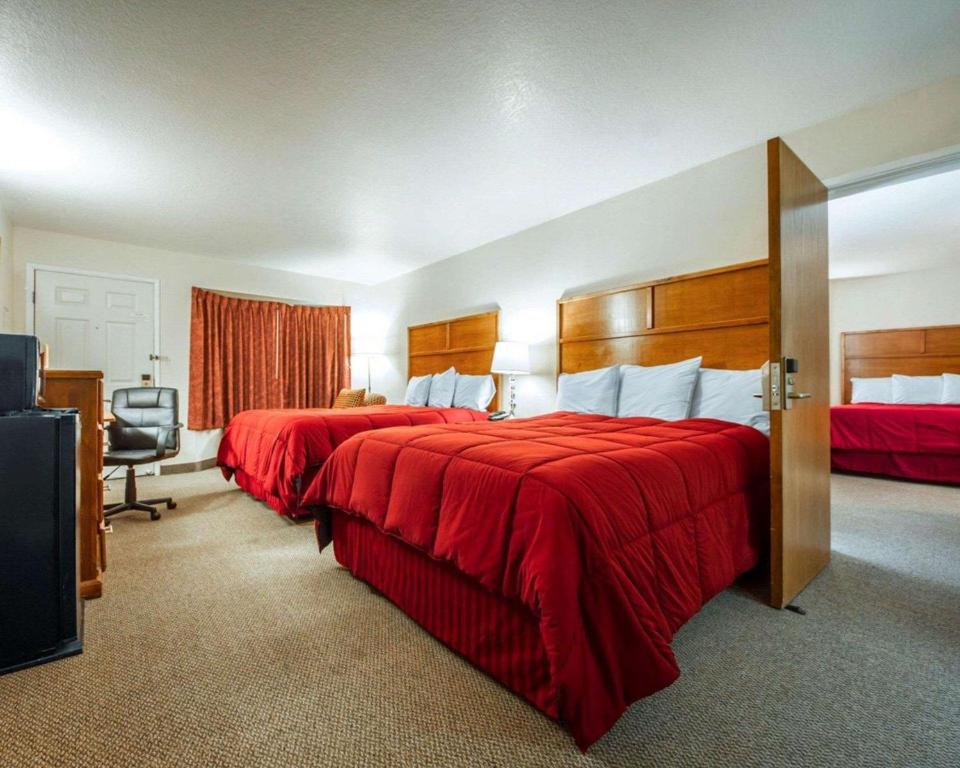 a hotel room with two beds with red sheets at Sea Drift Inn in Eureka