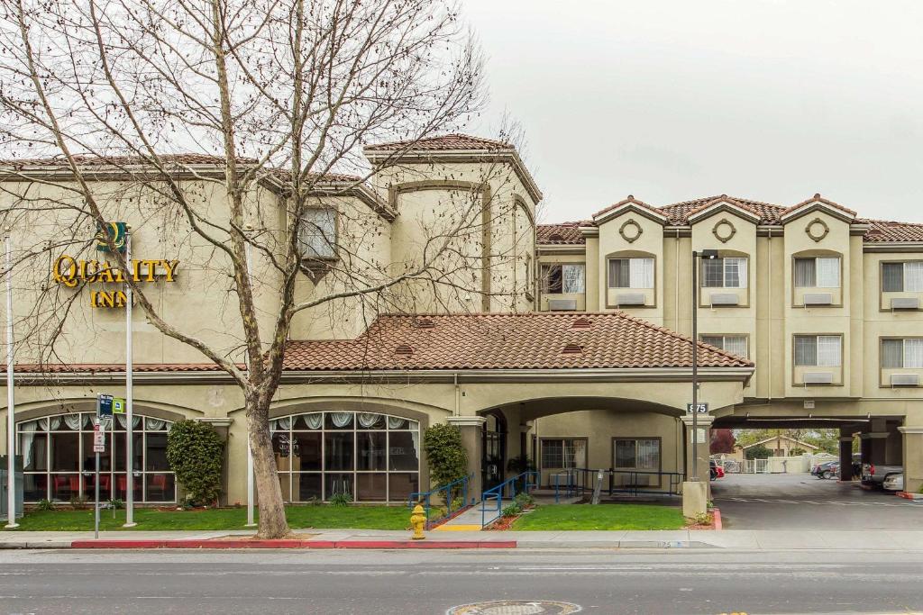 um edifício com uma placa que lê a estalagem universitária em Quality Inn San Jose em San Jose