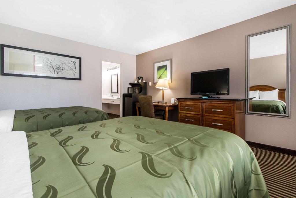 a hotel room with a bed and a flat screen tv at BaySide Inn & Suites Eureka in Eureka