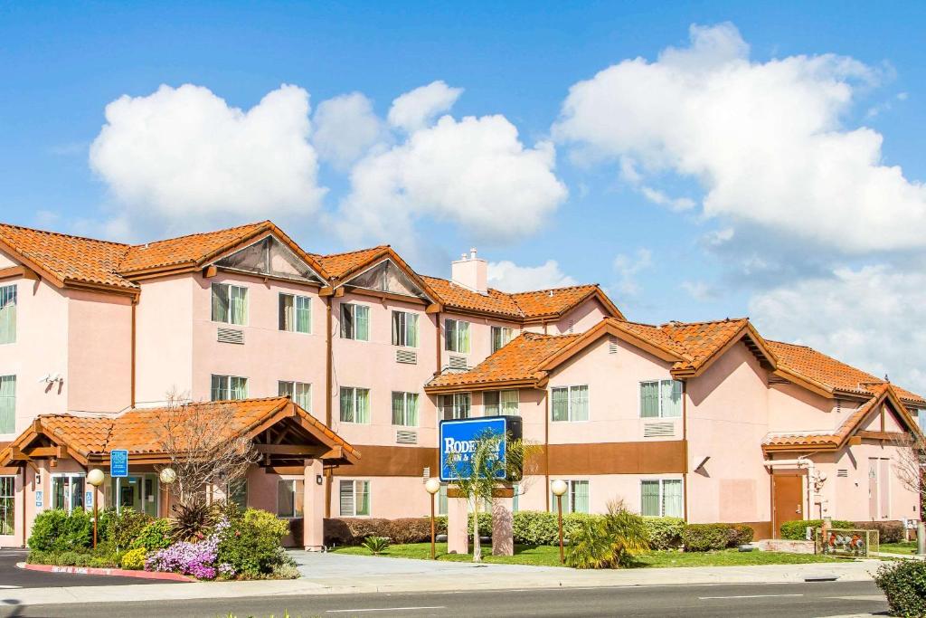 a large apartment building with orange roof at Rodeway Inn & Suites in Hayward