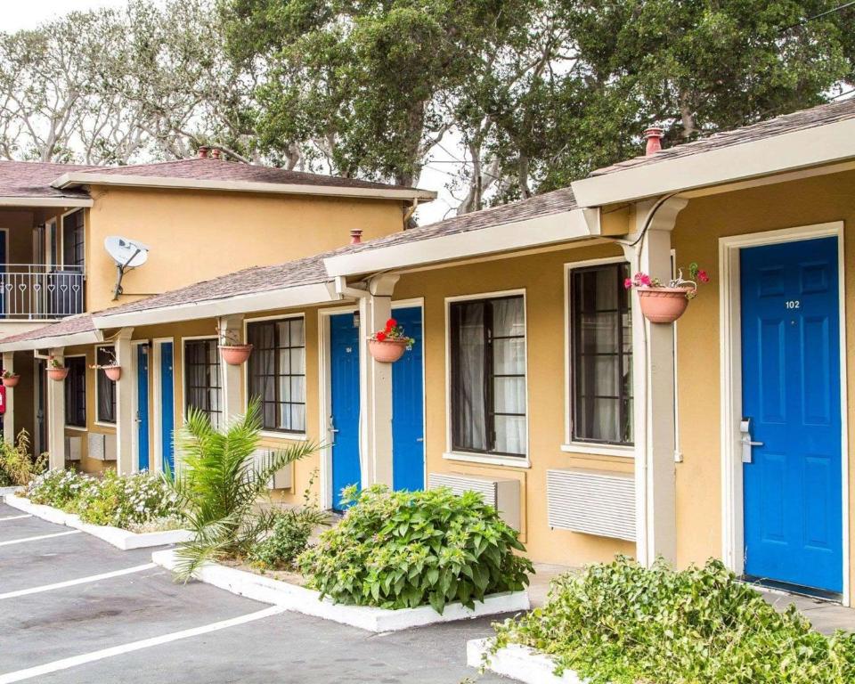 une rangée de maisons avec des portes et des plantes bleues dans l'établissement Rodeway Inn Monterey Near Fairgrounds, à Monterey
