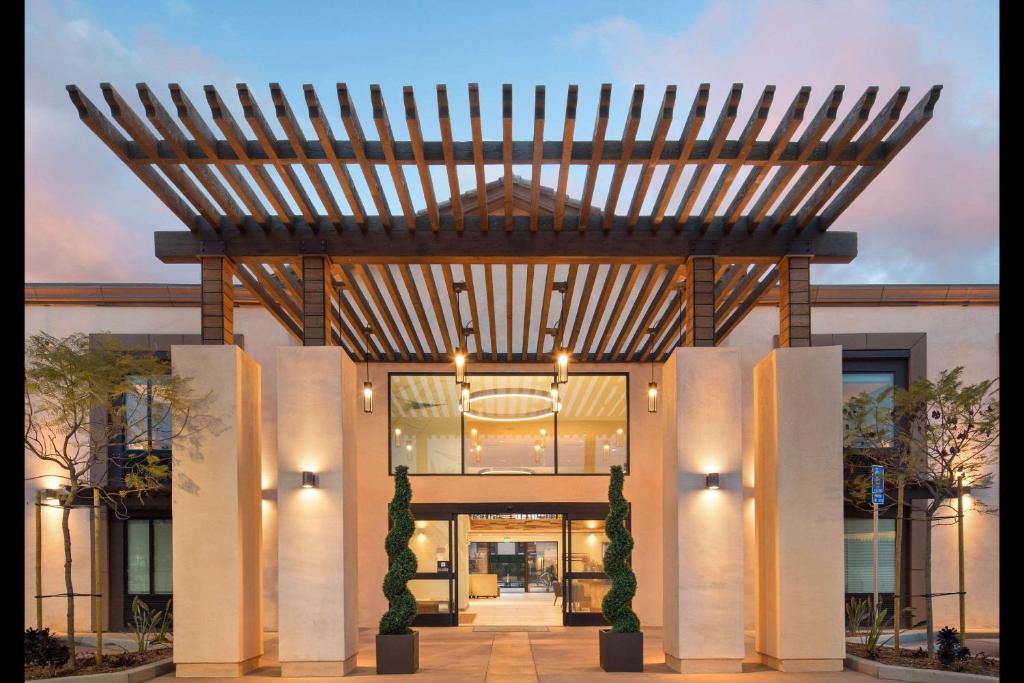 a large entrance to a building with a wooden pergola at The Cove Hotel in Long Beach