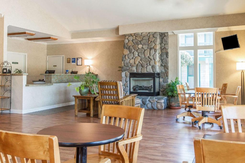 a living room with a table and chairs and a fireplace at Quality Inn Half Moon Bay-Miramar Beach in Half Moon Bay