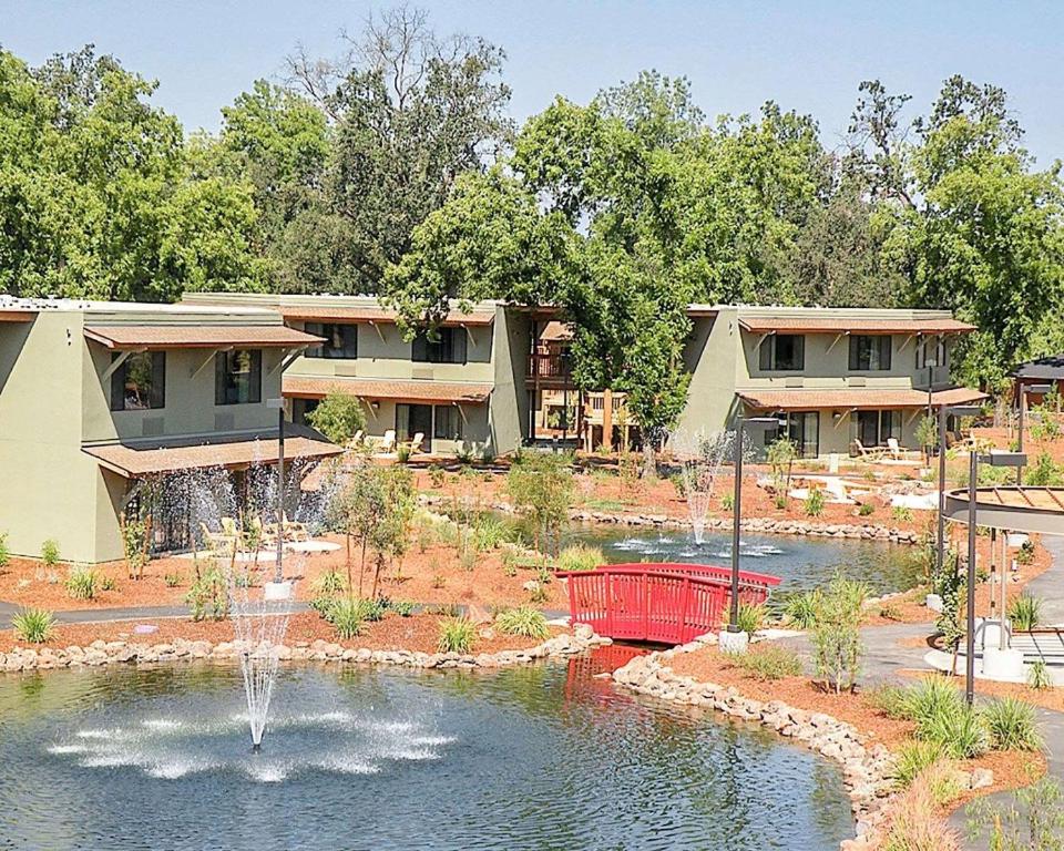 a house with a fountain in the middle of a pond at Gaia Hotel & Spa Redding, Ascend Hotel Collection in Anderson