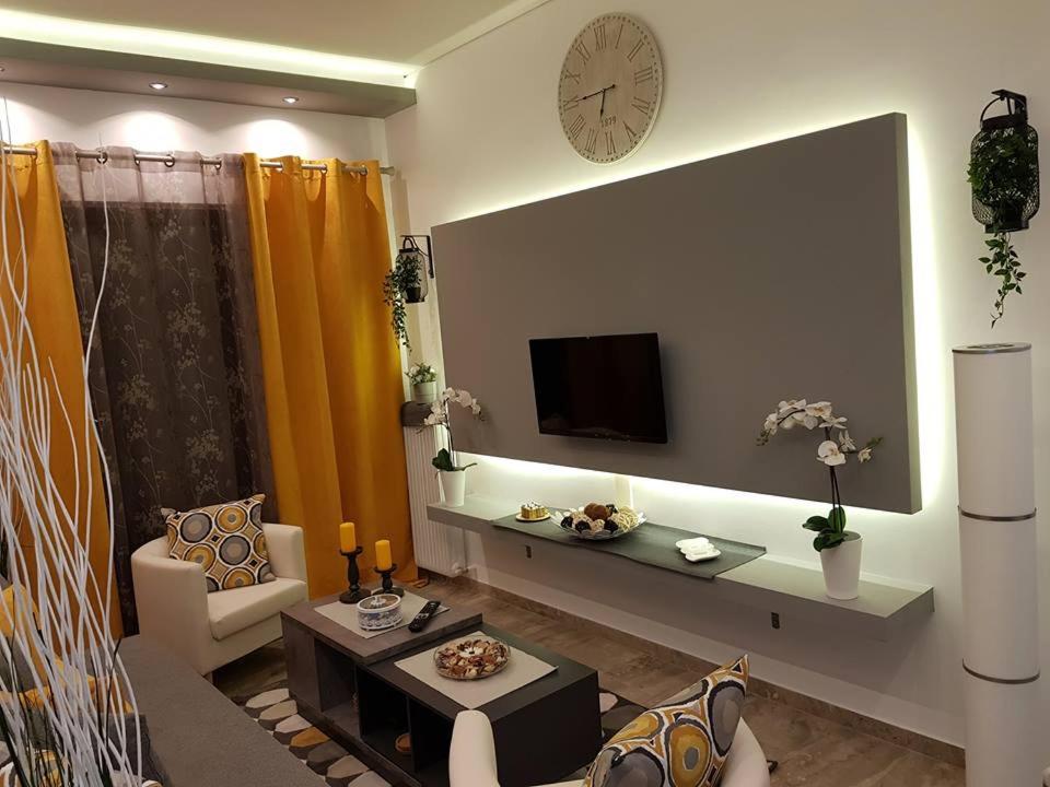 En TV eller et underholdningssystem på 'Golden Aurora' Apartment With Elegant Style