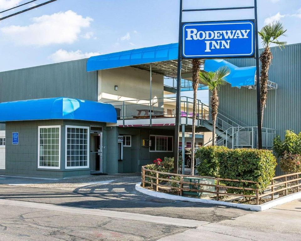 una señal de una posada en la carretera frente a un edificio en Rodeway Inn Downtown Hanford, en Hanford