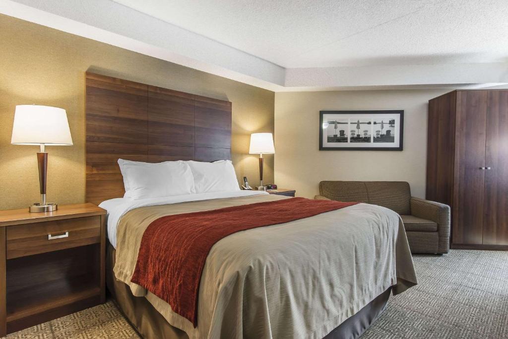 a hotel room with a bed and a chair at Comfort Inn in Huntsville