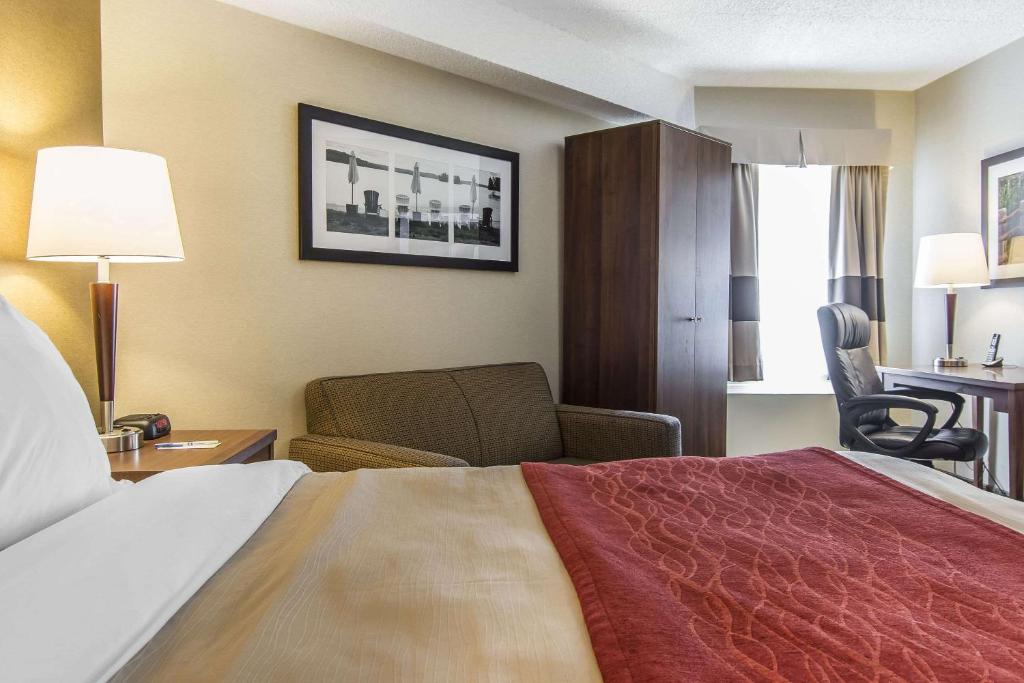 a hotel room with a bed and a chair at Comfort Inn in Huntsville