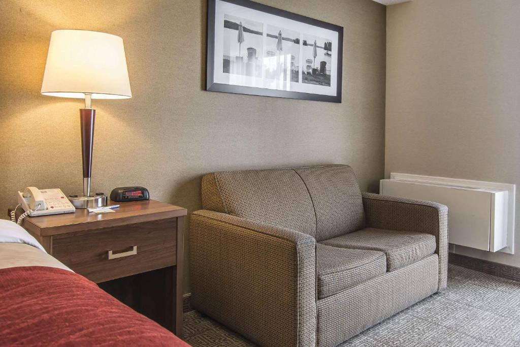 a hotel room with a chair and a lamp at Comfort Inn in Huntsville