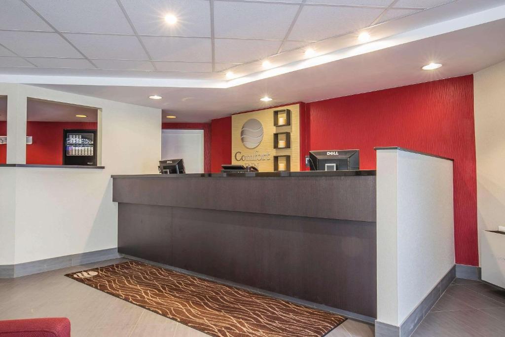 vestíbulo con recepción y paredes rojas en Comfort Inn Pickering en Pickering