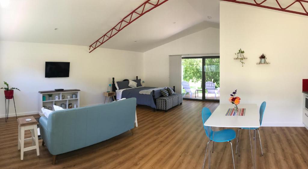 uma sala de estar com uma cama, uma mesa e cadeiras em Langleys Port Campbell Hobby Farm em Port Campbell