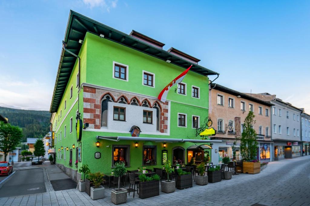 ein grünes Gebäude an der Straßenseite in der Unterkunft Hotel Gasthof Brüggler in Radstadt