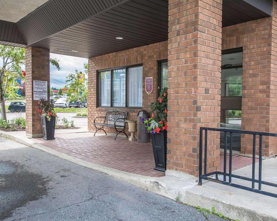 a brick building with a patio with flowers on it at Comfort Inn Alma in Alma