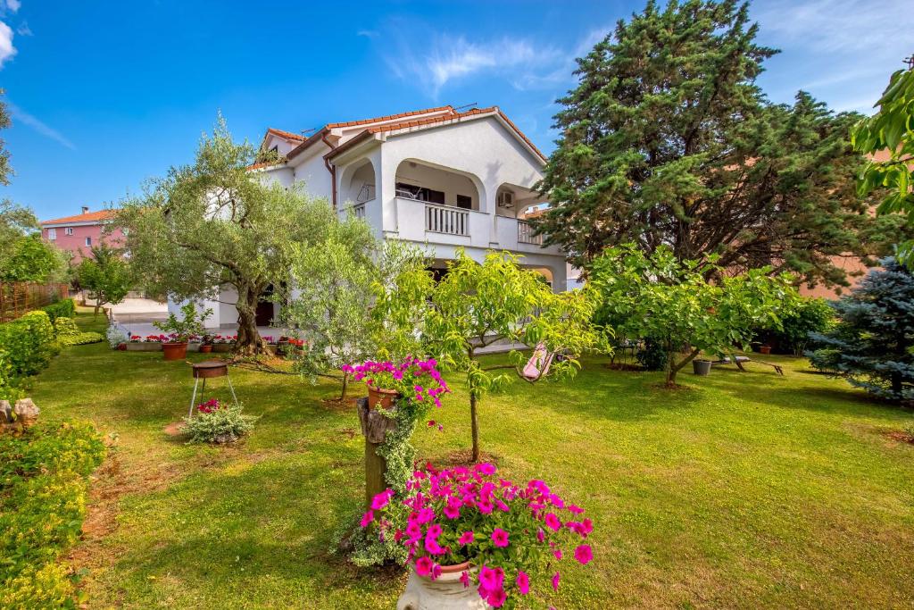 ein Haus mit rosa Blumen im Hof in der Unterkunft Garden paradise App in Sveti Vid-Miholjice