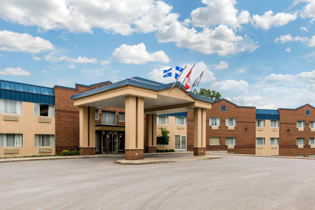 a building with two flags on top of it at Comfort Inn & Suites Shawinigan in Shawinigan