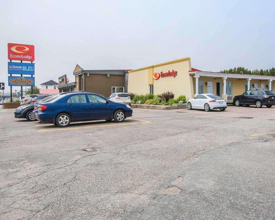 a car parked in a parking lot in front of a dealership at Econo Lodge Forestville in Forestville