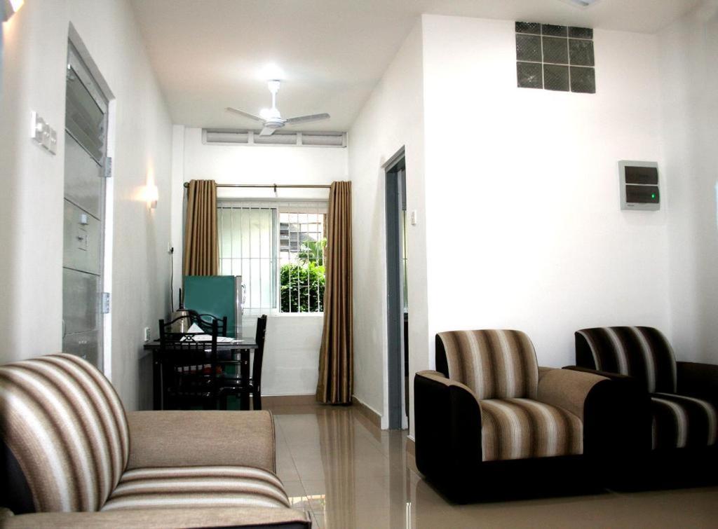 a living room with two chairs and a couch at Bamba Flat in Colombo