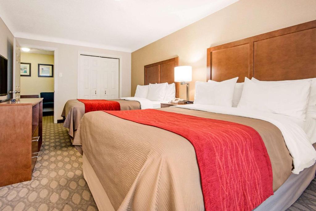 a hotel room with two beds and a flat screen tv at Comfort Inn Fallsview in Niagara Falls