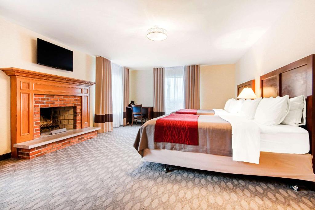 a hotel room with a bed and a fireplace at Comfort Inn Fallsview in Niagara Falls