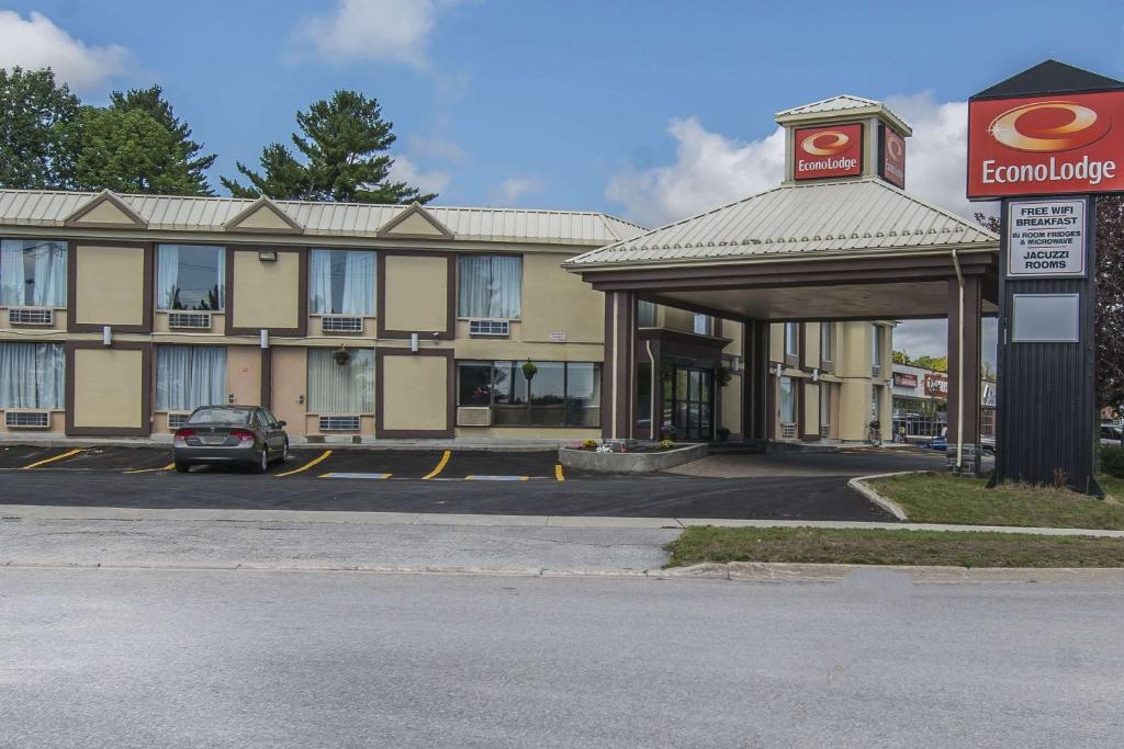 a hotel with a car parked in a parking lot at Econo Lodge in Orillia