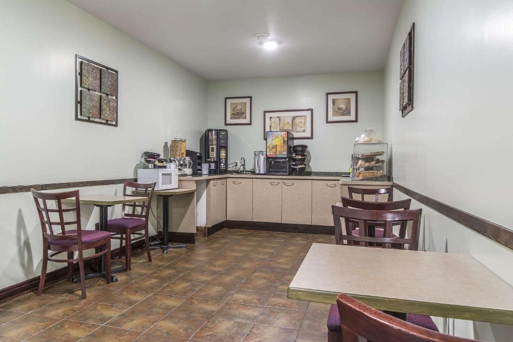 een restaurant met tafels en stoelen en een bar bij Econolodge Huntsville in Huntsville