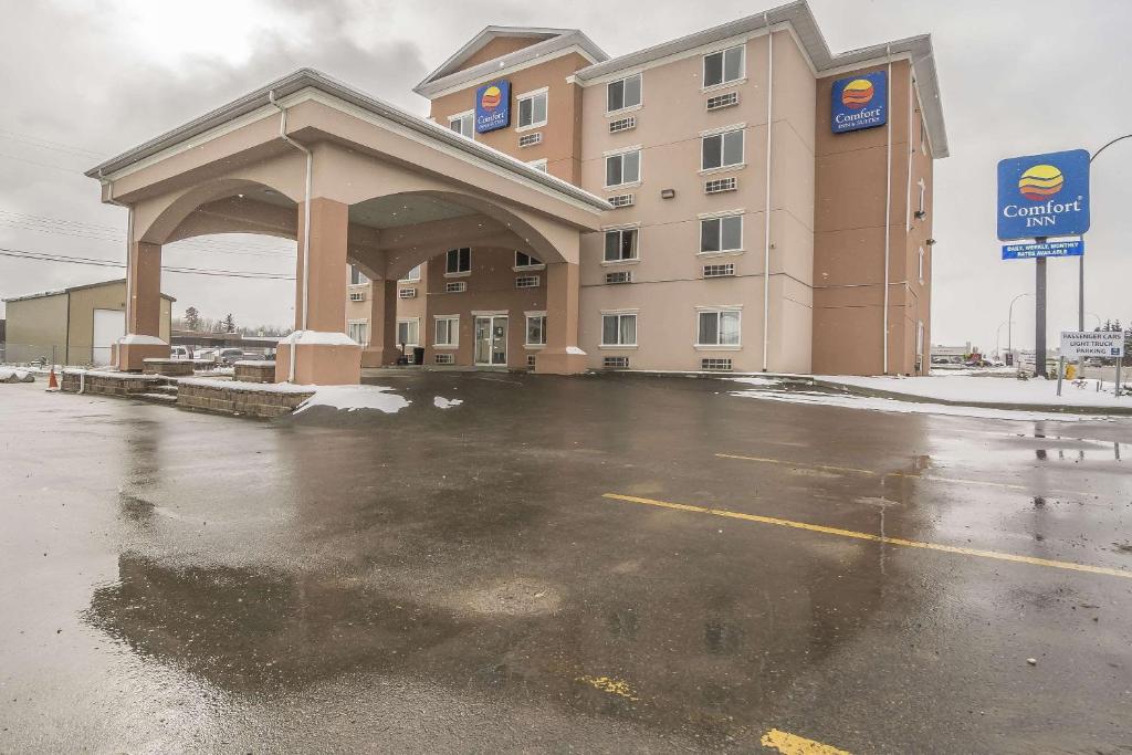 a hotel parking lot in front of a building at Comfort Inn & Suites Edson in Edson