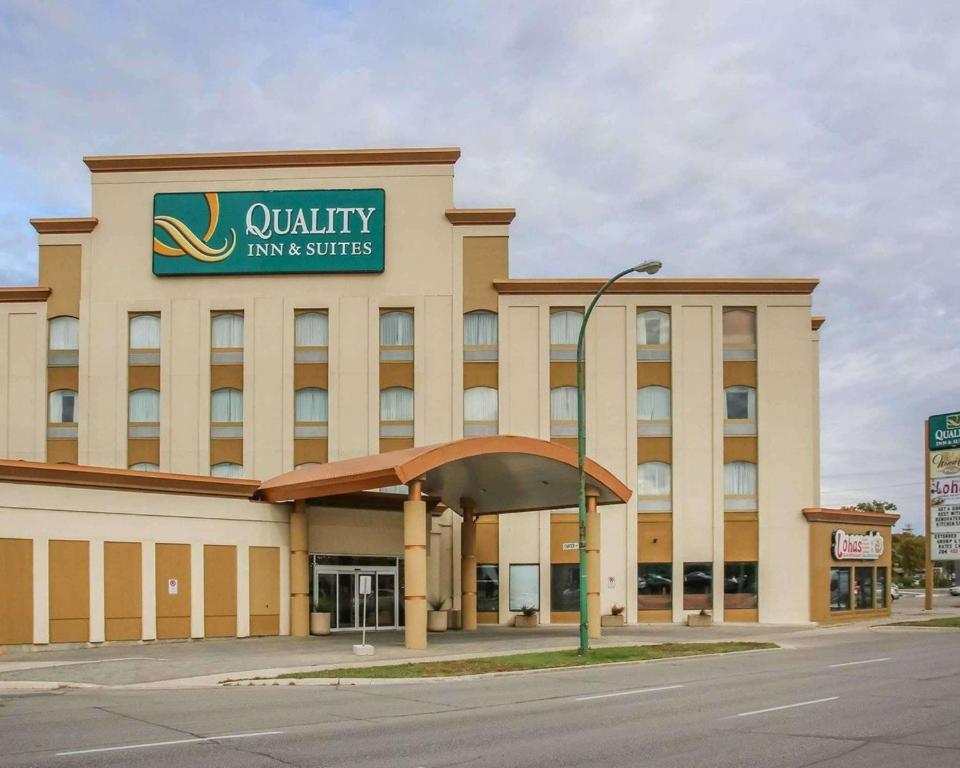 una posada universitaria y un edificio de suites con un cartel. en Quality Inn & Suites Winnipeg, en Winnipeg